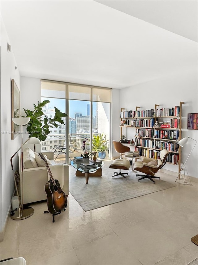 sitting room featuring a wall of windows and concrete floors