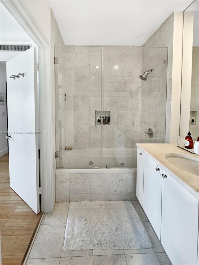 bathroom with tiled shower / bath and vanity