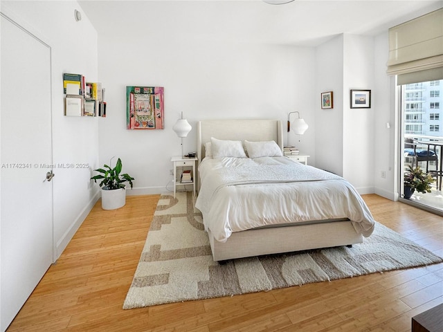 bedroom featuring hardwood / wood-style flooring and access to outside