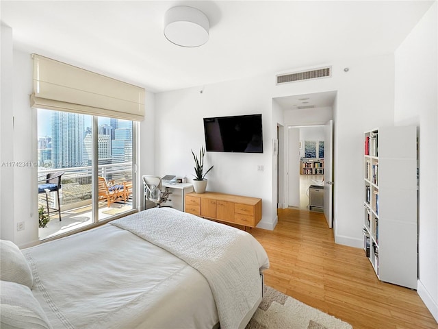 bedroom featuring access to outside and light hardwood / wood-style floors