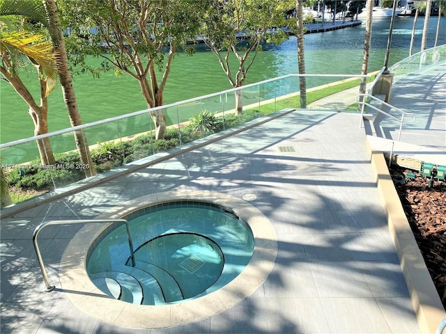 view of pool featuring an in ground hot tub and a water view