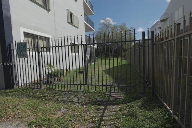 view of gate with a yard