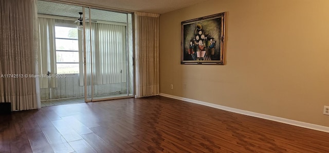 spare room featuring dark hardwood / wood-style flooring and ceiling fan