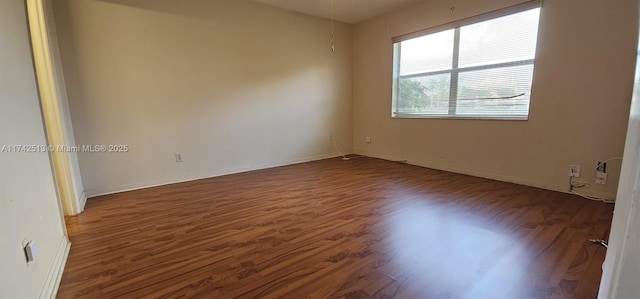 spare room featuring dark hardwood / wood-style flooring