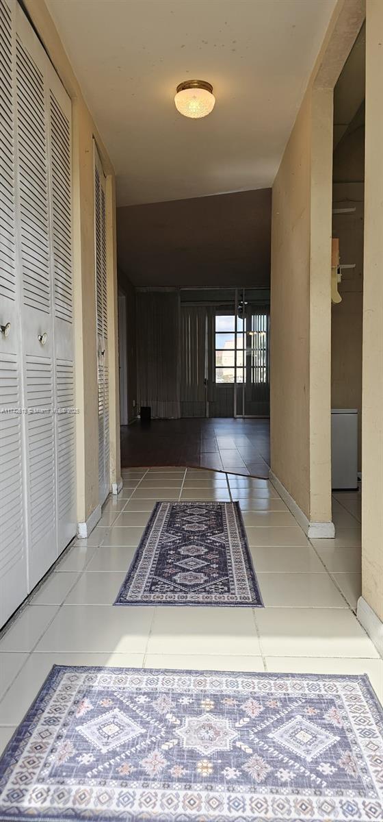 hall with tile patterned floors