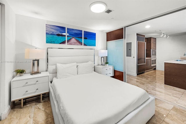 bedroom featuring paneled refrigerator, electric panel, and sink