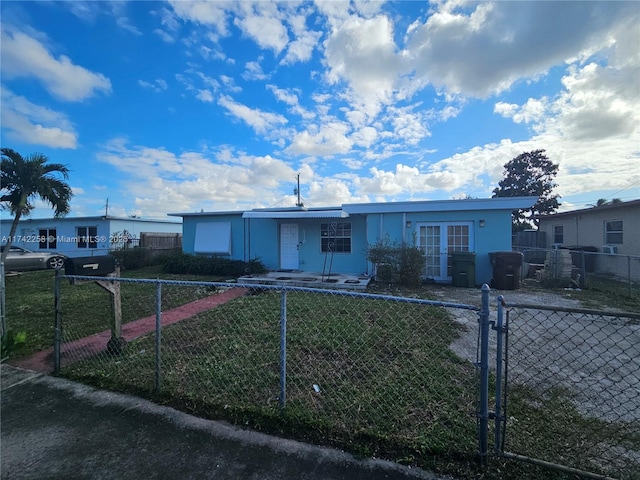 single story home featuring french doors and a front lawn