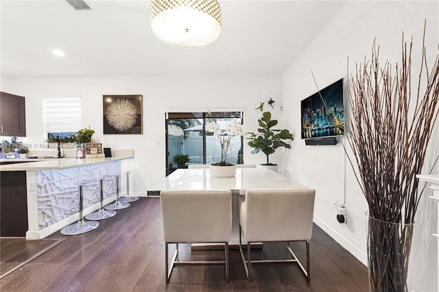 dining space featuring sink and dark wood-type flooring