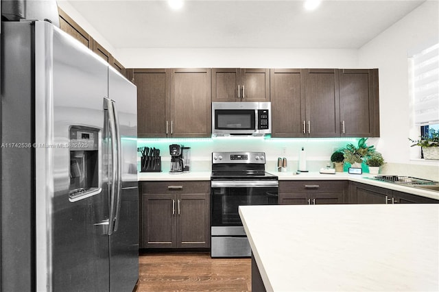 kitchen featuring appliances with stainless steel finishes, dark hardwood / wood-style floors, sink, and dark brown cabinets