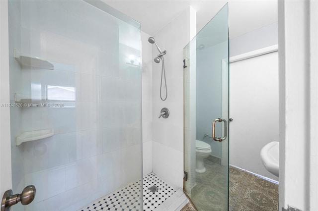 bathroom with toilet and a shower with door