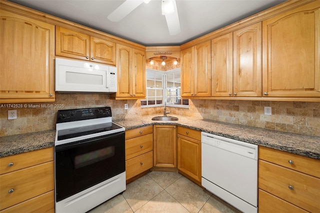 kitchen featuring sink, dark stone countertops, backsplash, light tile patterned floors, and white appliances