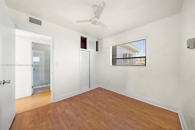 unfurnished bedroom with hardwood / wood-style flooring, ceiling fan, and a closet