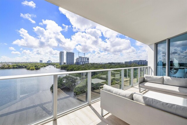 balcony featuring an outdoor living space and a water view