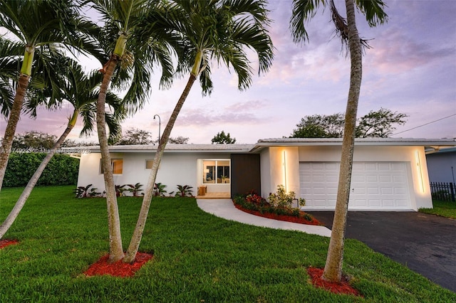 view of front facade with a garage and a lawn