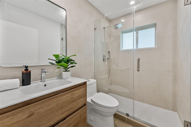 bathroom with tasteful backsplash, tile walls, vanity, an enclosed shower, and toilet