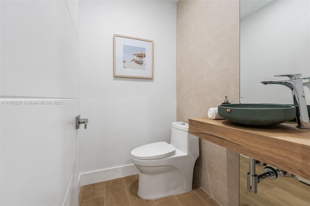 bathroom featuring sink, hardwood / wood-style floors, and toilet