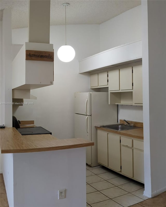 kitchen with sink, pendant lighting, cream cabinetry, and kitchen peninsula