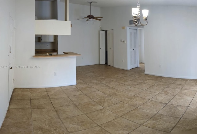 empty room with light tile patterned floors, ceiling fan, and a high ceiling