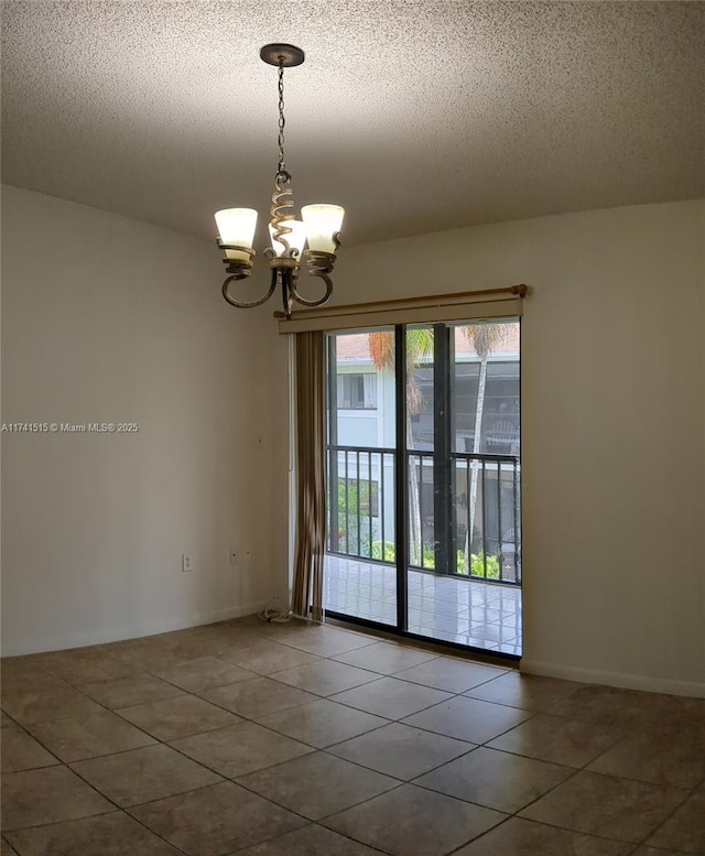 tiled empty room with a textured ceiling and a notable chandelier