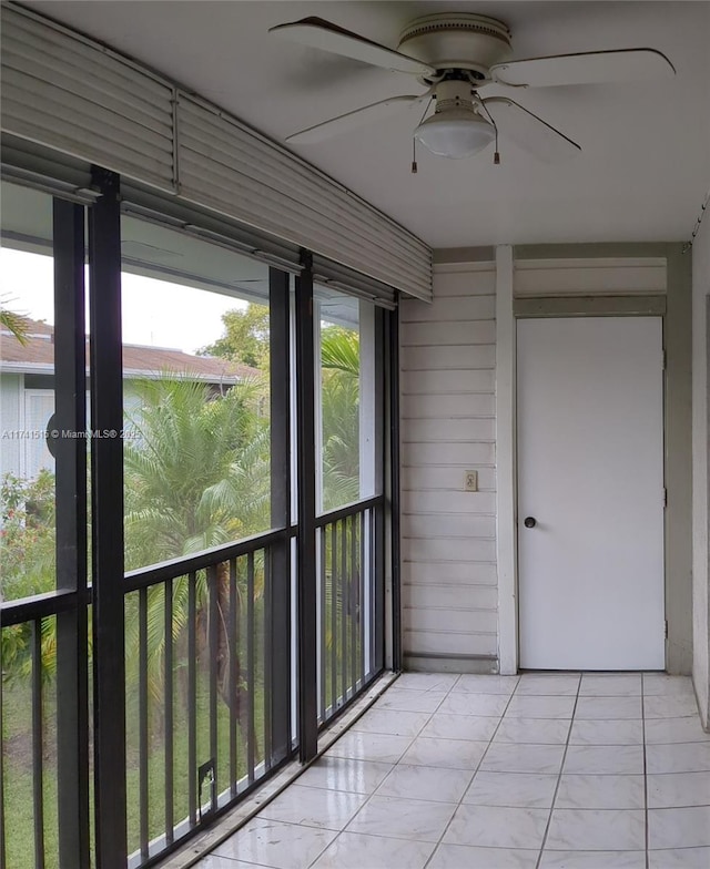 unfurnished sunroom featuring ceiling fan