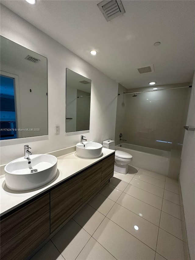 full bathroom featuring tiled shower / bath combo, vanity, tile patterned flooring, and toilet