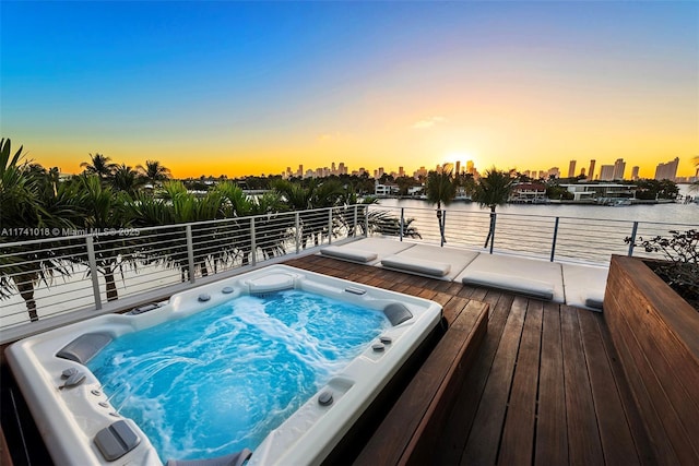 pool at dusk featuring a water view