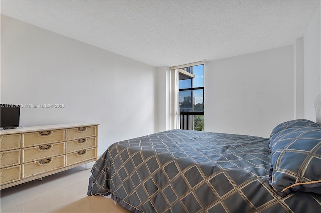 bedroom with floor to ceiling windows and a textured ceiling