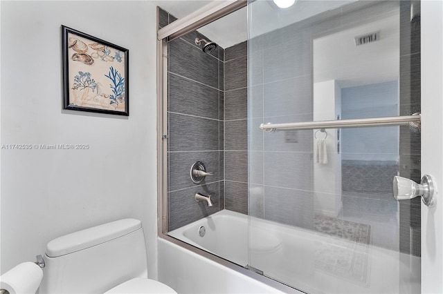 bathroom featuring shower / bath combination with glass door and toilet