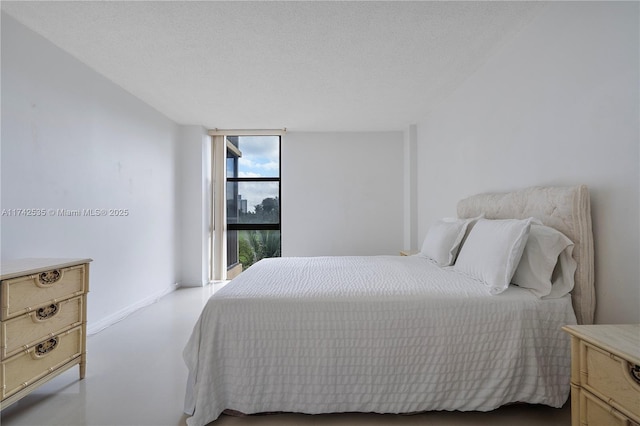 bedroom with a wall of windows and a textured ceiling