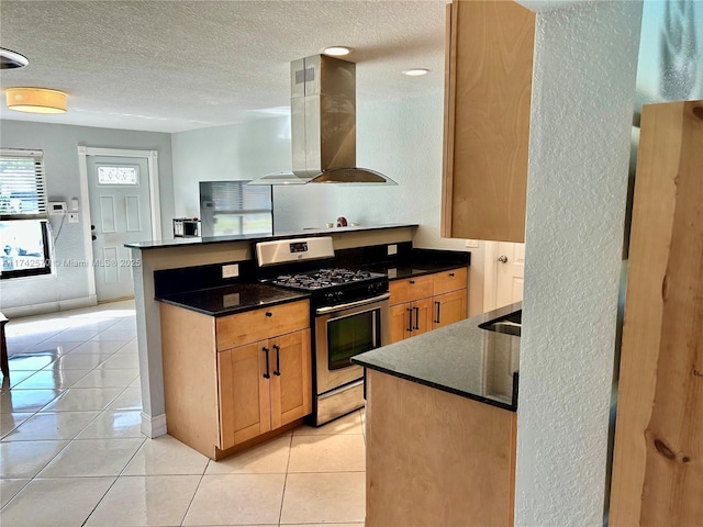 kitchen featuring light tile patterned floors, gas stove, island exhaust hood, and a textured ceiling