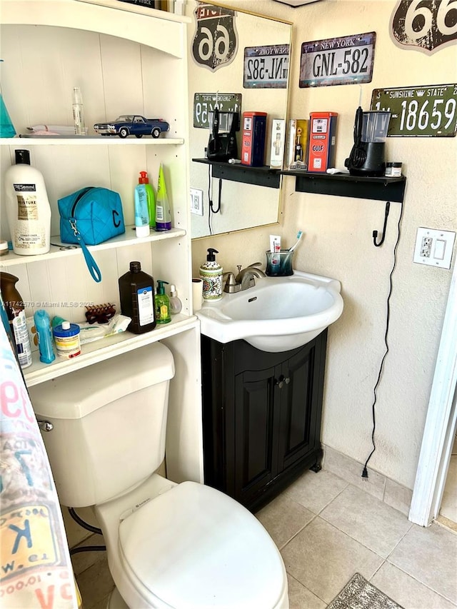 bathroom with vanity, toilet, and tile patterned floors