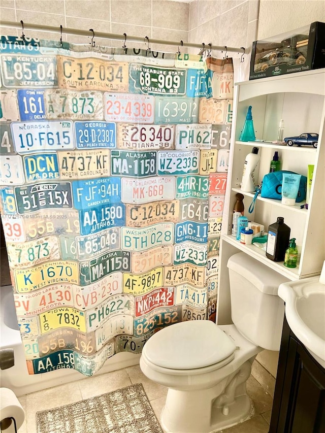 bathroom featuring vanity, tile patterned flooring, and toilet