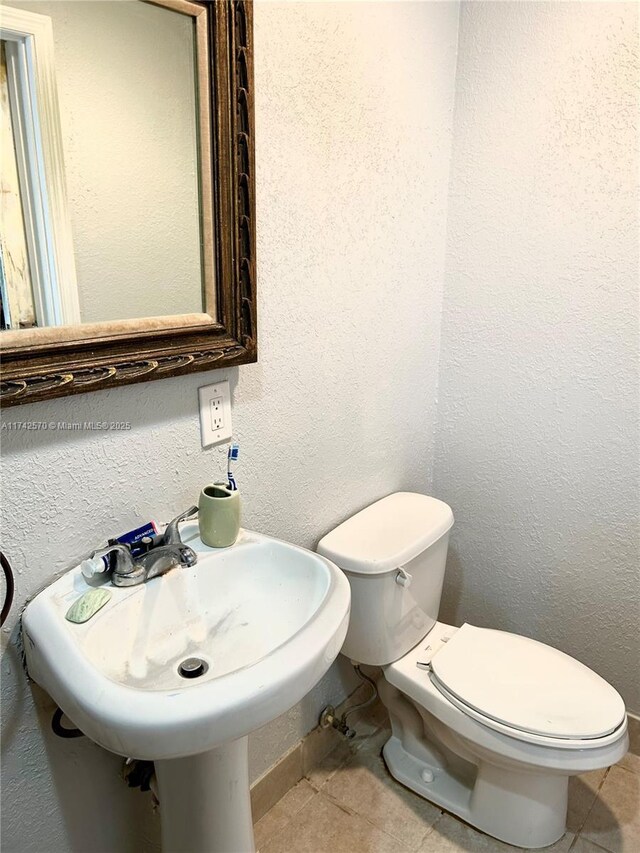 bathroom featuring sink, tile patterned flooring, and toilet