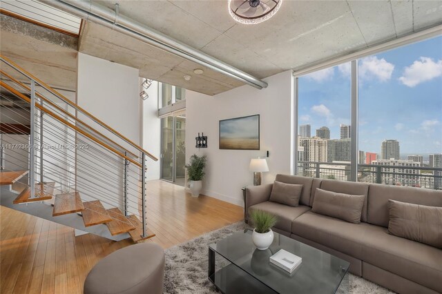 living room with a wall of windows and light wood-type flooring