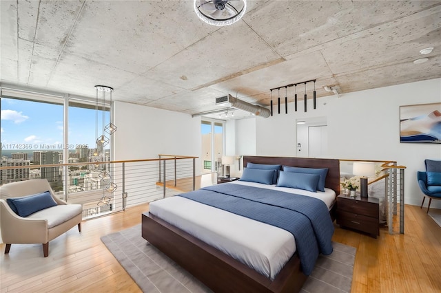 bedroom with wood-type flooring and floor to ceiling windows