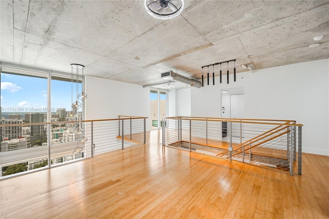 empty room featuring expansive windows and hardwood / wood-style floors