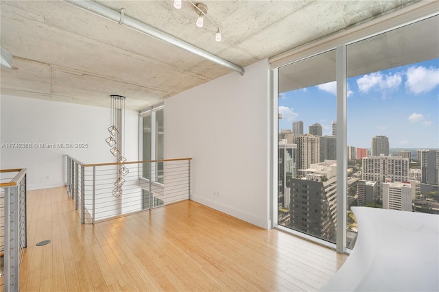 empty room with a wall of windows and wood-type flooring