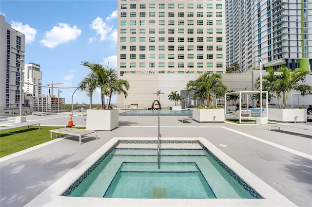 view of swimming pool with a hot tub and a patio