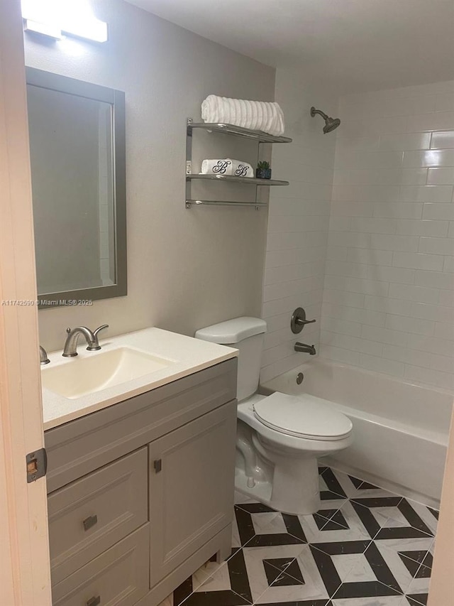 full bathroom featuring vanity, tiled shower / bath combo, and toilet