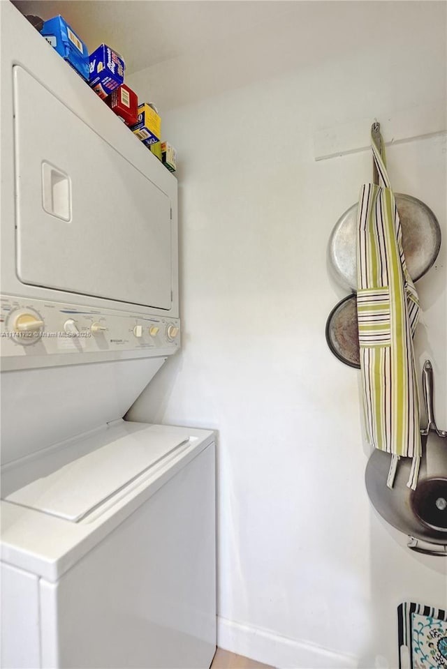 clothes washing area featuring stacked washer and clothes dryer