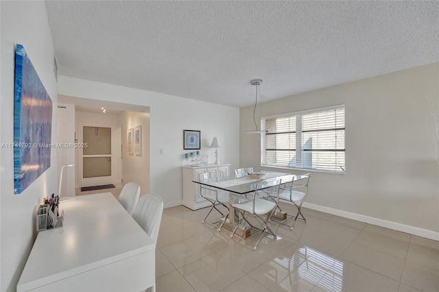 tiled dining space with a textured ceiling