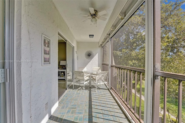 unfurnished sunroom featuring ceiling fan