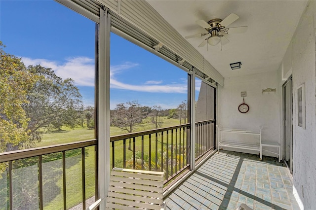 unfurnished sunroom with ceiling fan