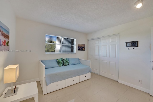 living area with light tile patterned flooring and a textured ceiling