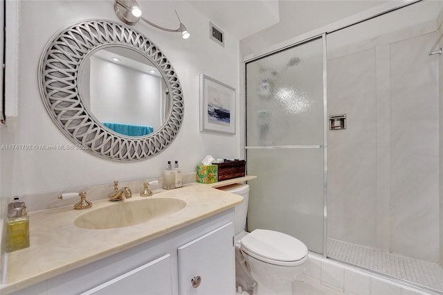 bathroom featuring vanity, an enclosed shower, and toilet