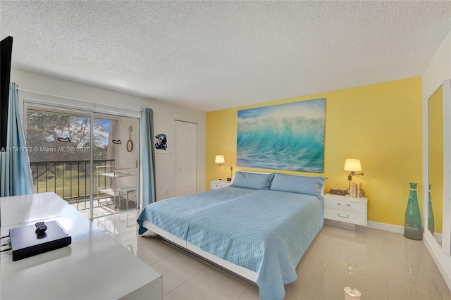 bedroom featuring access to outside, a textured ceiling, and light tile patterned flooring