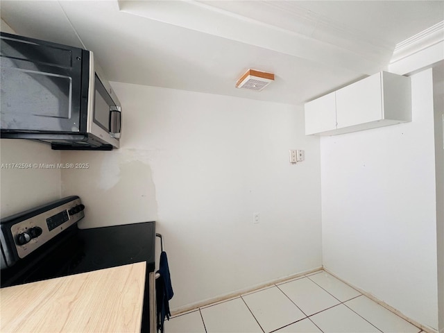 kitchen with white cabinetry, stainless steel appliances, and light tile patterned floors