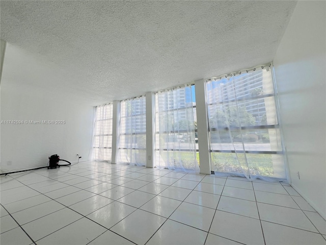 tiled spare room with floor to ceiling windows and a textured ceiling