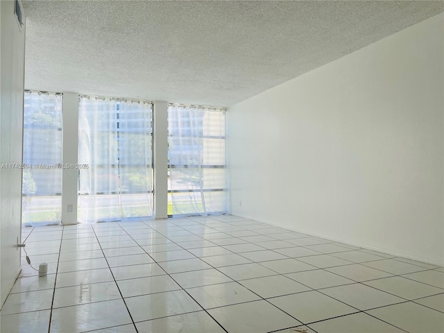 tiled empty room with expansive windows and a textured ceiling