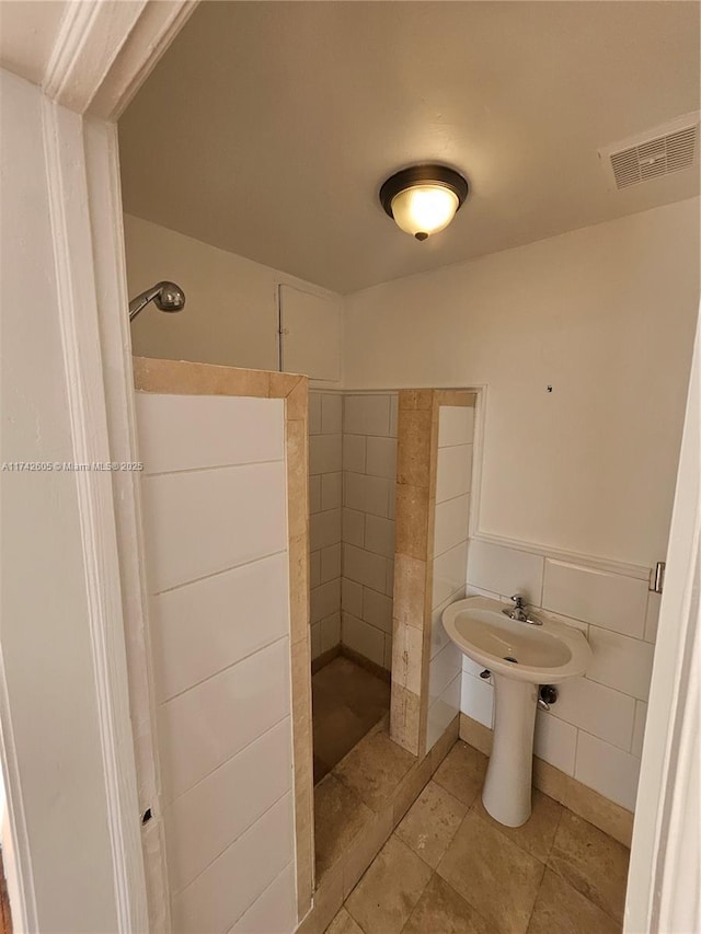 bathroom featuring tiled shower and tile patterned floors